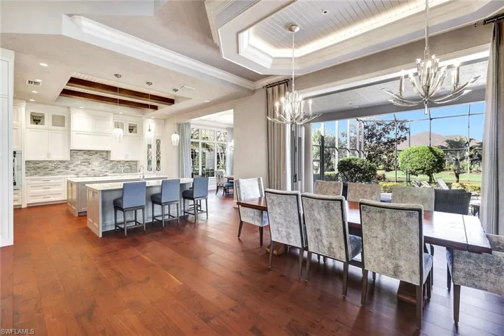 Dining space featuring a tray ceiling, crown molding, dark hardwood / wood-style flooring, and a healthy amount of sunlight