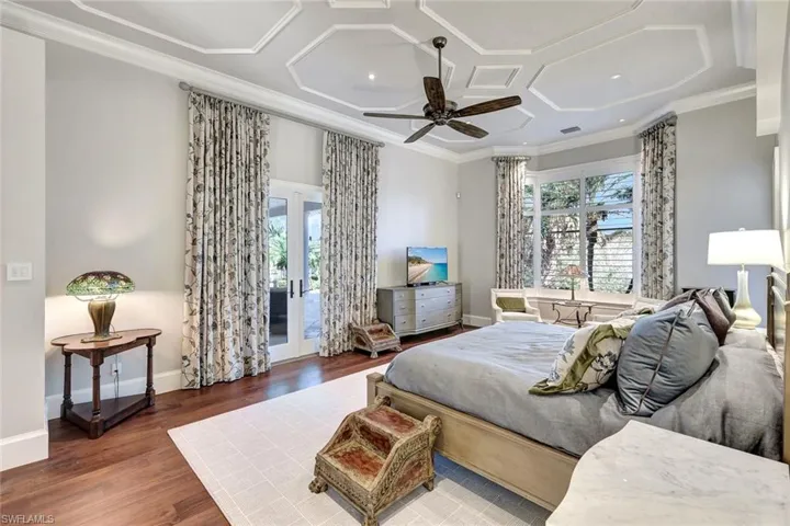 Bedroom featuring coffered ceiling, ceiling fan, access to exterior, ornamental molding, and dark hardwood / wood-style flooring