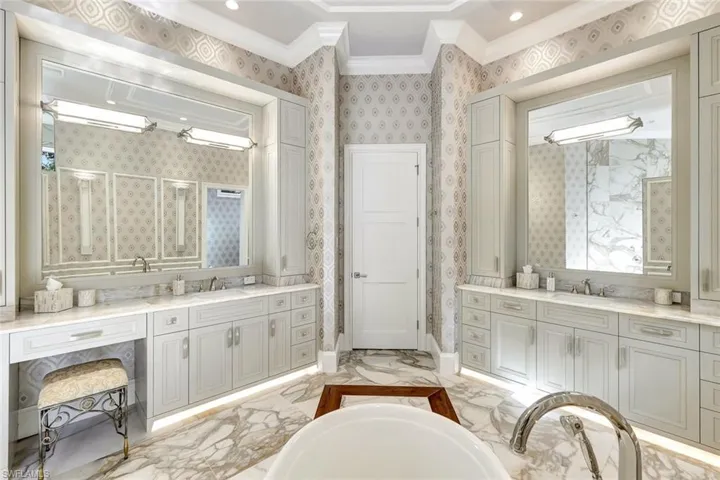 Bathroom featuring a washtub, vanity, and ornamental molding