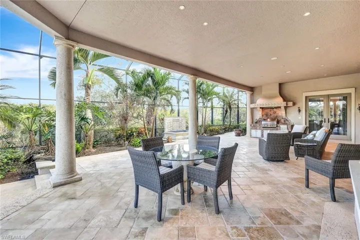 View of patio featuring an outdoor stone fireplace, area for grilling, and french doors
