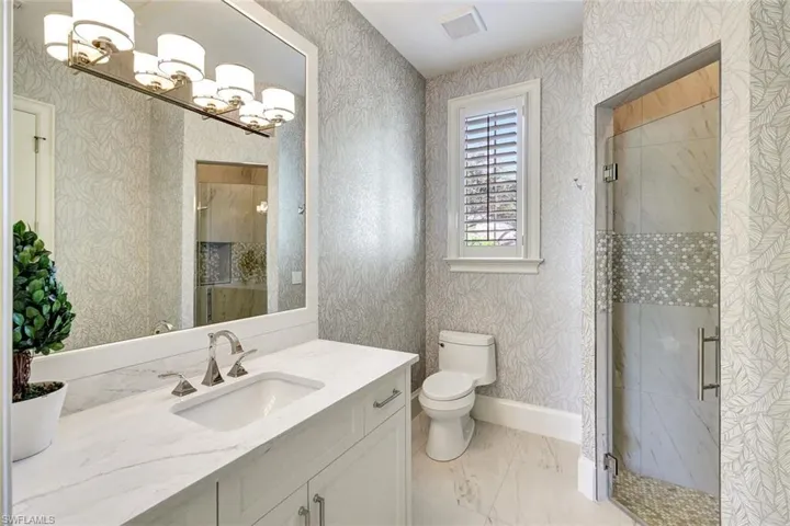 Bathroom featuring toilet, vanity, and walk in shower