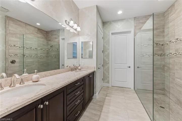 Dual vanity featuring a light-toned countertop, undermount sinks, and dark wood-finish cabinetry