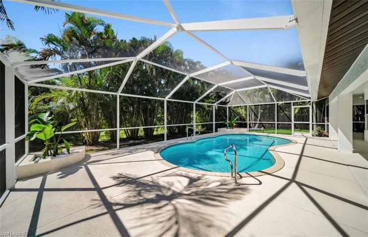 Swimming pool with a sunroom, a lanai, and a patio area