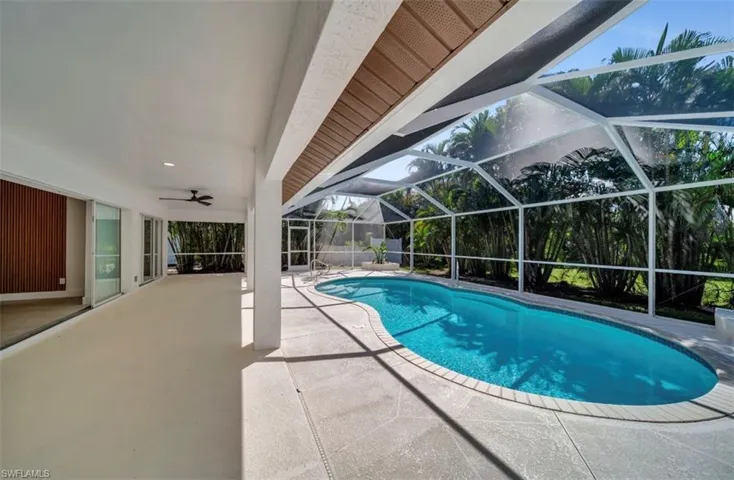 Swimming pool featuring a patio, a lanai, a sunroom, and ceiling fan