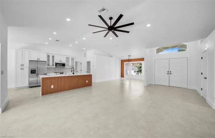 Unfurnished living room featuring a ceiling fan, recessed lighting, and high vaulted ceiling