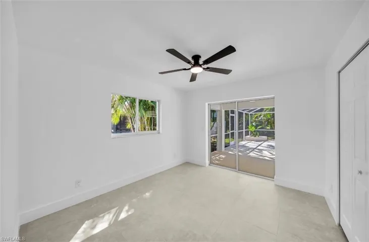 Unfurnished bedroom featuring access to outside, a closet, ceiling fan, and light tile patterned floors