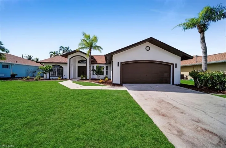Ranch-style home with stucco siding, concrete driveway, a front yard, and an attached garage