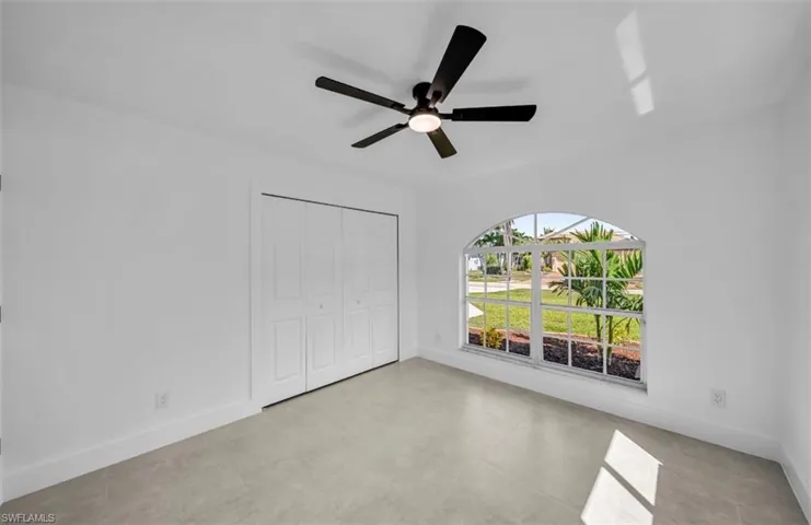 Unfurnished bedroom featuring ceiling fan and a closet