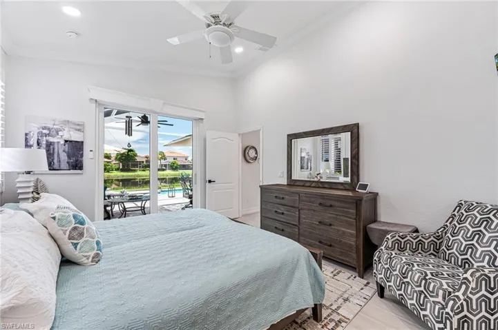 Primary suite with impact sliders to the pool with electric room darkening blinds