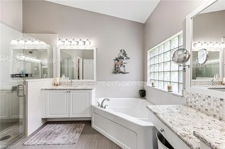 Primary bath with seamless glass walk-in shower, dual sink areas