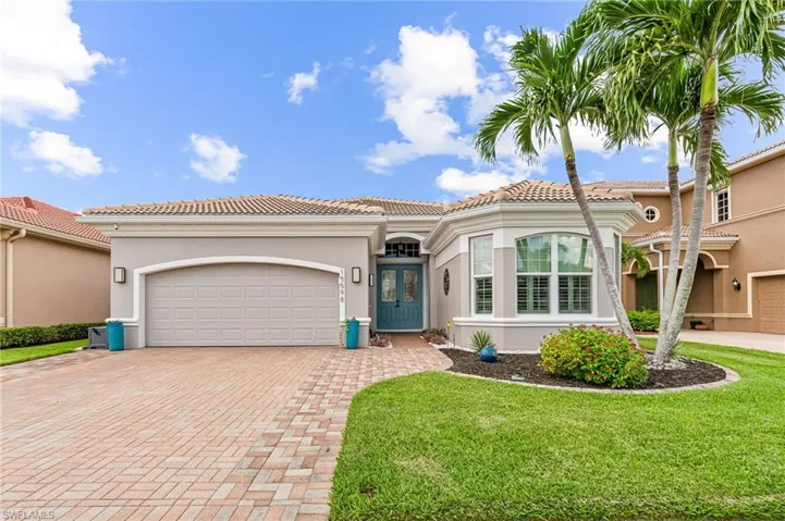 Front view of home with extended paver drive and beautiful landscaping