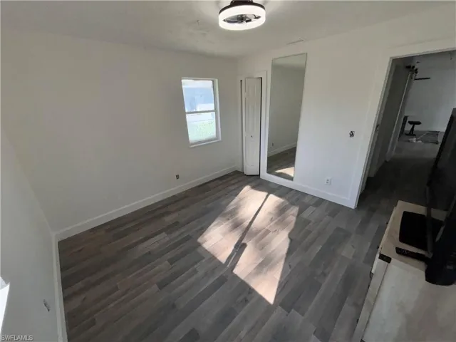 Unfurnished bedroom with dark wood finished floors and a closet