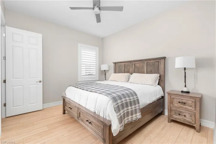 En Suite 2nd bedroom...Wood floor, plantation shutters & custom fan