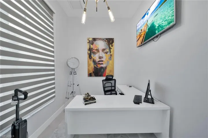Home office featuring light marble finish flooring and a chandelier