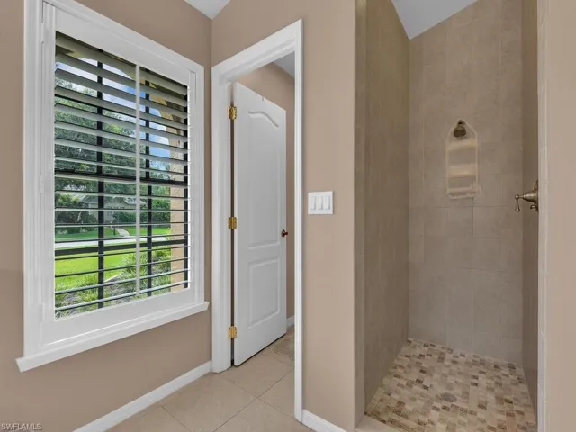 Full bath with tile patterned floors and tiled shower