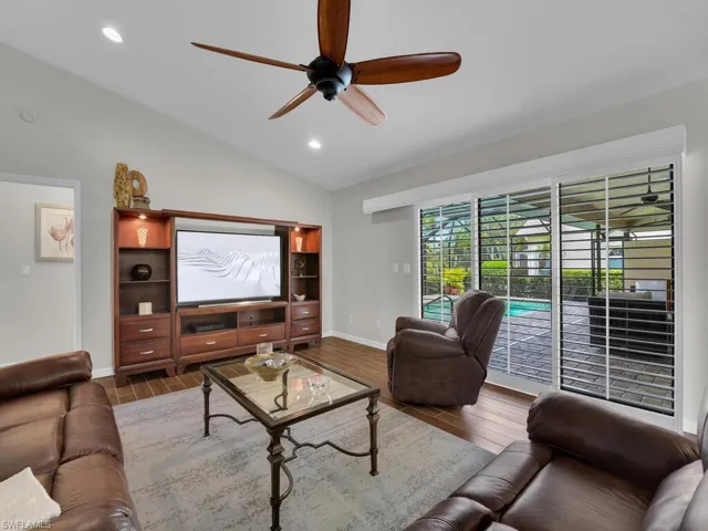 Living area with lofted ceiling, ceiling fan, wood finished floors, and recessed lighting