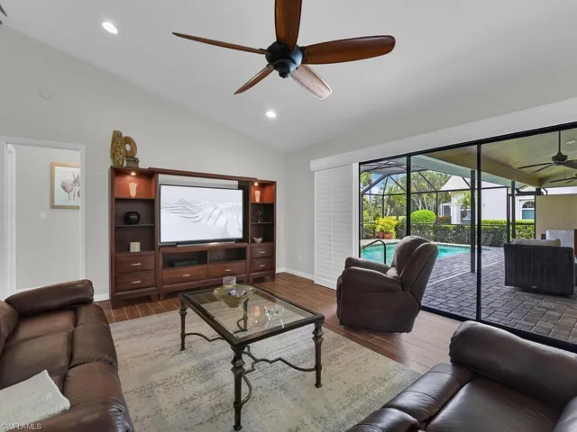 Living area featuring a ceiling fan, vaulted ceiling, wood finished floors, recessed lighting, and a sunroom