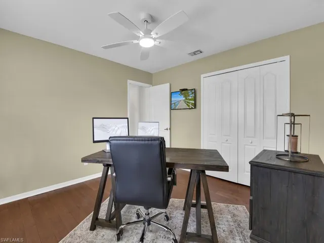 Office area with dark wood finished floors and ceiling fan