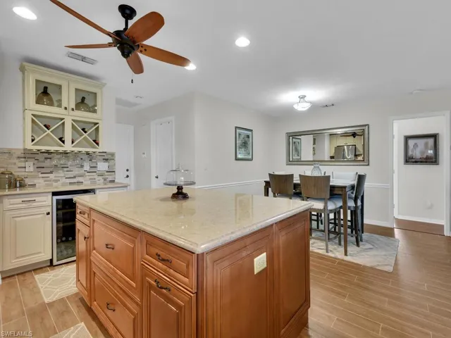 Kitchen with wood tiled floors, recessed lighting, a center island, brown cabinets, and stainless steel microwave