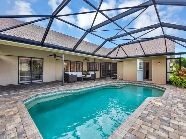 Outdoor pool featuring a patio, outdoor lounge area, a ceiling fan, and glass enclosure
