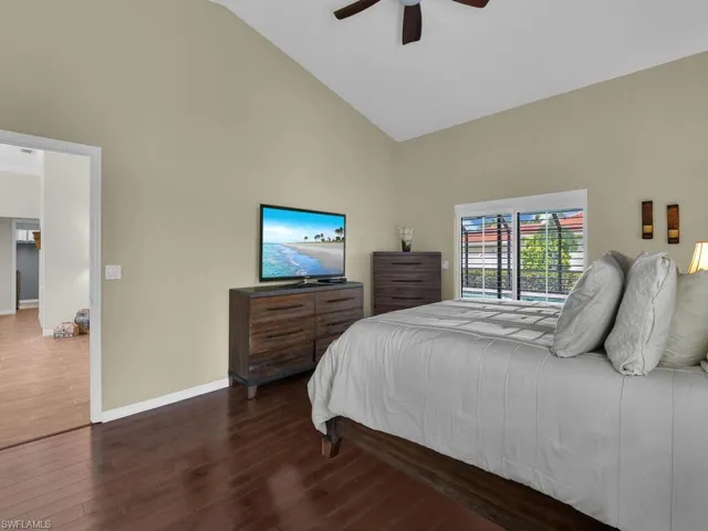 Bedroom featuring high vaulted ceiling, wood finished floors, and ceiling fan