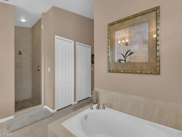 Full bath with a bath, tile patterned flooring, and a tile shower