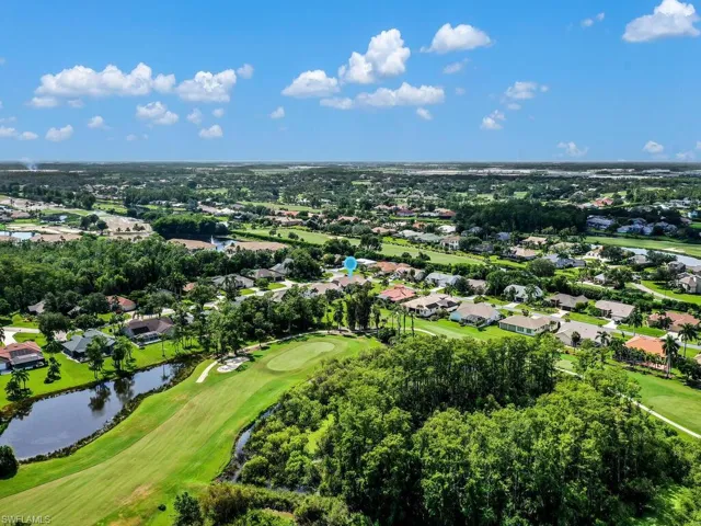 Aerial view of residential area with a local golf course and a nearby body of water
