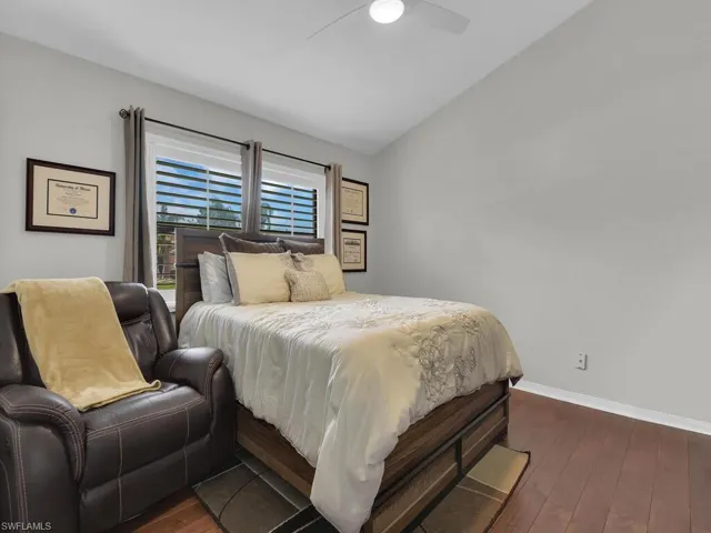Bedroom featuring lofted ceiling, dark wood-style flooring, and ceiling fan