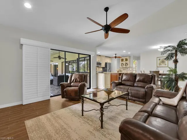 Living room featuring recessed lighting, wood finished floors, and vaulted ceiling