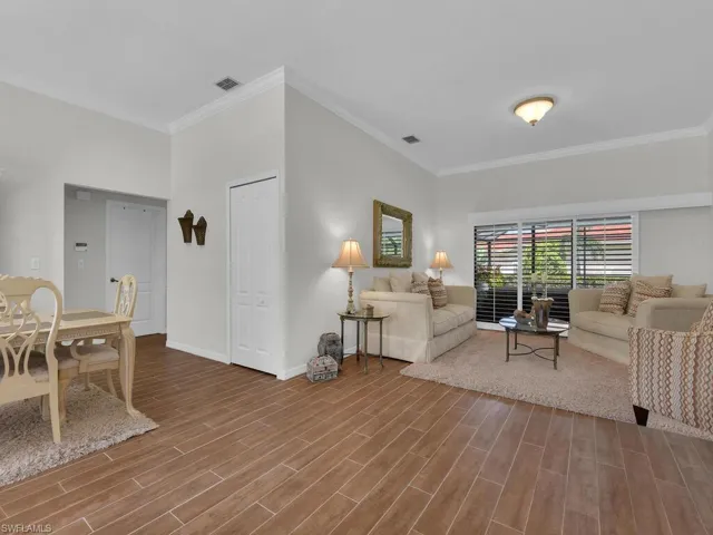 Living area with ornamental molding and wood finish floors