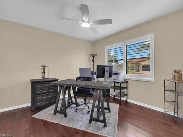 Home office featuring dark wood-style flooring and a ceiling fan