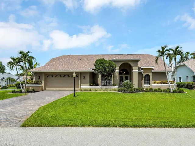 View of front of home featuring stucco siding, a front lawn, and an attached garage