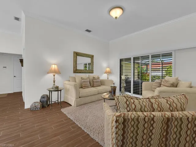 Living area featuring wood tiled floors and ornamental molding