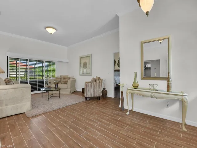 Living room featuring crown molding and wood tiled floors