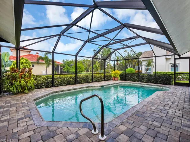 Outdoor pool with a patio and glass enclosure