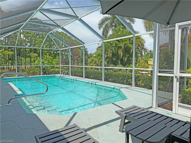 Swimming pool with a lanai, a sunroom, and a patio area
