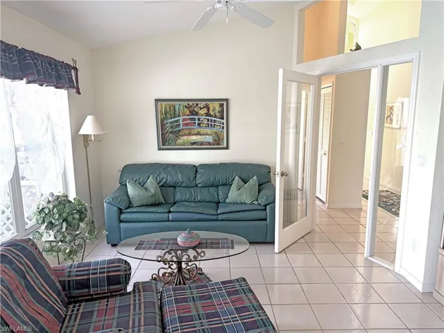 Living area featuring tile patterned flooring, french doors, and vaulted ceiling