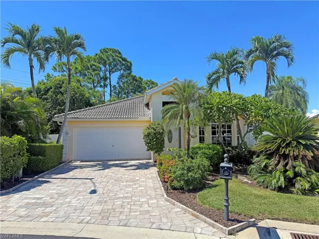 View of front of property with decorative driveway, stucco siding, a tile roof, and a 2-car garage