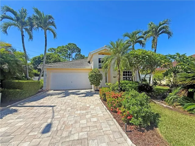 View of front facade with decorative driveway, an attached garage, stucco siding, and a tile roof