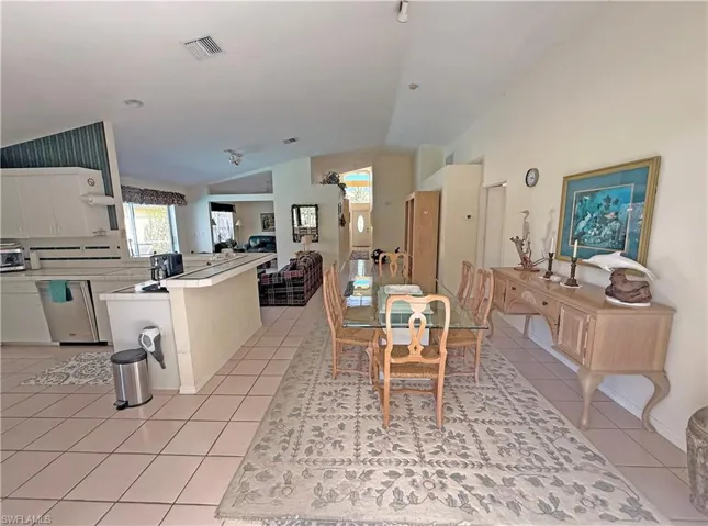 Dining space featuring lofted ceiling and light tile patterned floors