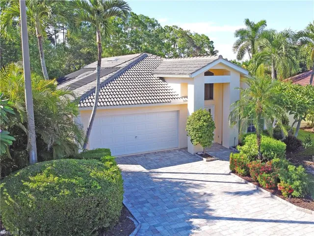 View of front of house featuring a tiled roof, stucco siding, decorative driveway, and a garage
