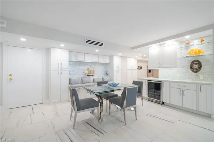 Dining space featuring light tile patterned flooring and beverage cooler