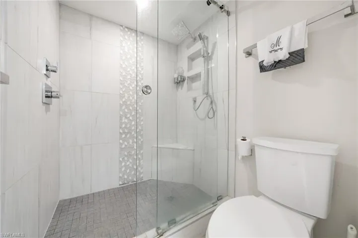 Bathroom with a shower with door and toilet