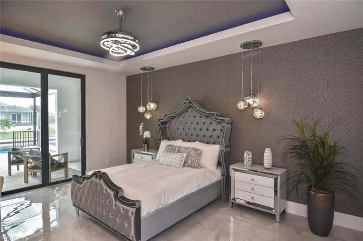 Bedroom featuring a raised ceiling, access to outside, and an accent wall
