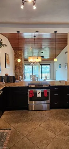 Kitchen with hanging light fixtures, stainless steel range with electric cooktop, wood ceiling, and an inviting chandelier