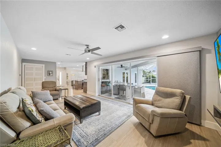 Rear view of property with a fenced backyard, a lanai, and an outdoor pool