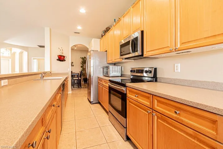 Kitchen featuring appliances with stainless steel finishes, light tile patterned flooring, and sink