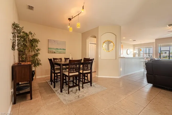 Dining area with rail lighting, light tile patterned floors, and ceiling fan