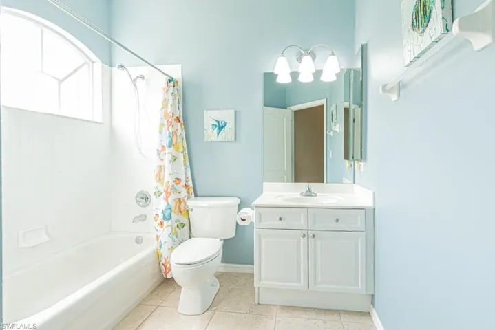 Full bathroom featuring vanity, toilet, tile patterned flooring, and shower / tub combo with curtain
