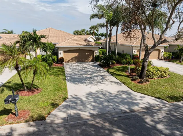 Mediterranean / spanish-style home featuring a garage and a front lawn